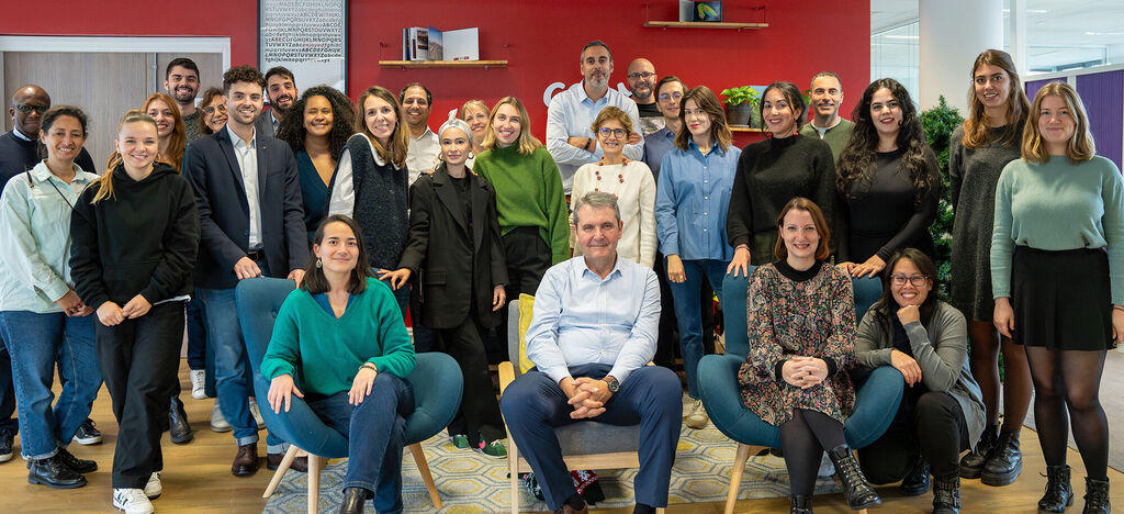 Photo de groupe d'une équipe joyeuse dans des bureaux modernes, rayonnant de joie et de collaboration.