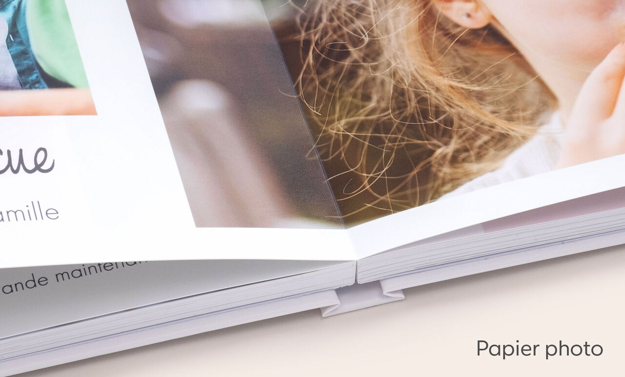 Zoom sur la reliure d'un album photo A4 paysage ouvert et avec ouverture à plat montrant des photos d'enfants imprimées sur papier photo