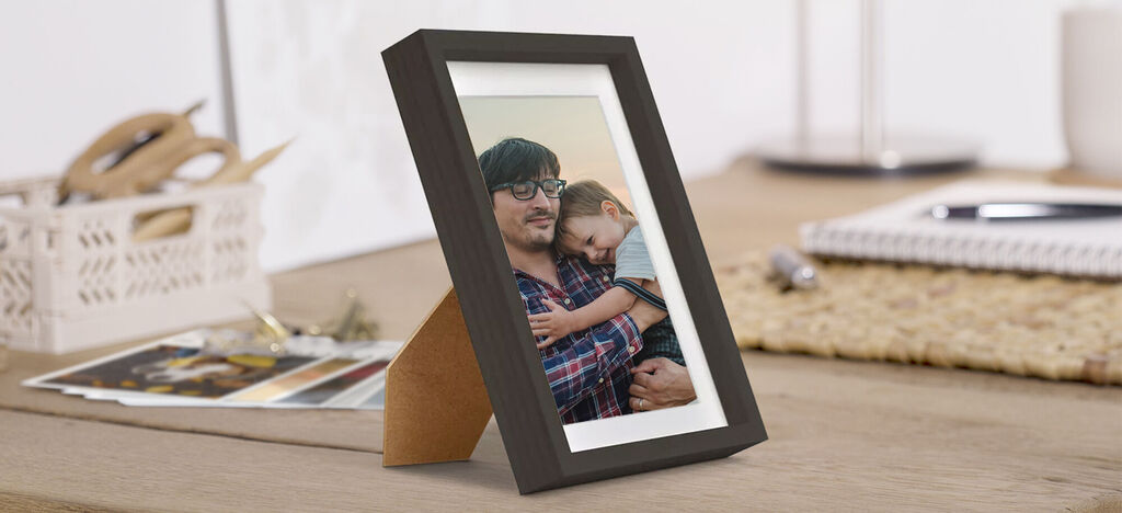 Une belle photo encadrée sur une table en bois montrant une étreinte chaleureuse.