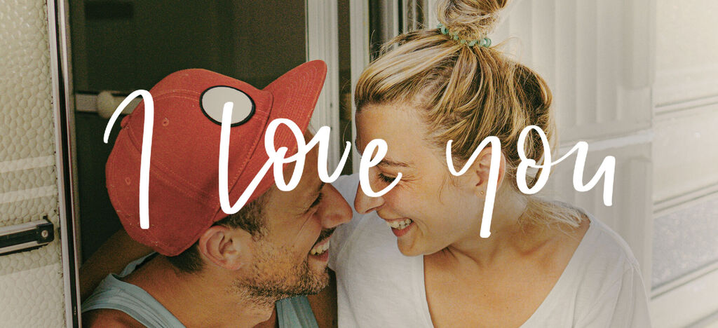 Des personnes amoureuses se regardent et sourient dans un camping-car