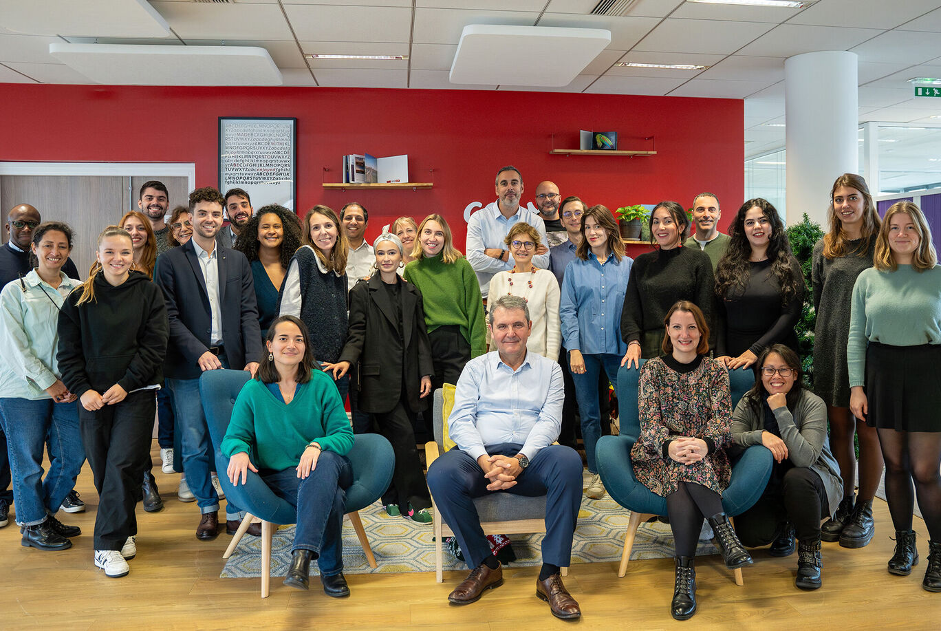 Photo de groupe d'une équipe joyeuse dans un bureau moderne, tous souriant et ensemble.