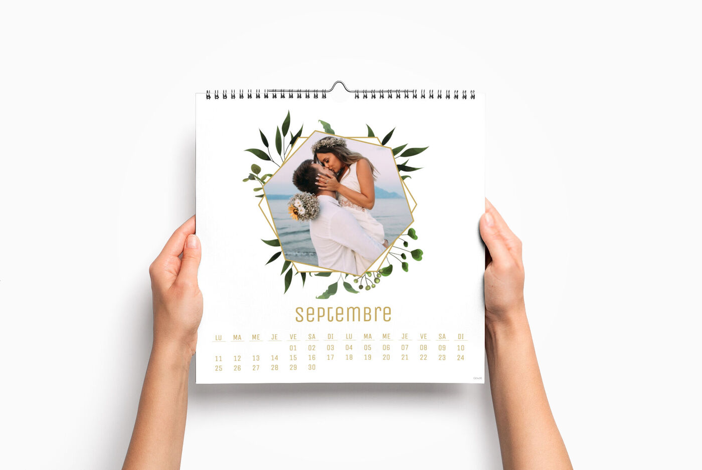 Un calendrier personnalisé carré entre les mains d'une personne, avec une photo de 2 mariés pour illustrer le mois de septembre