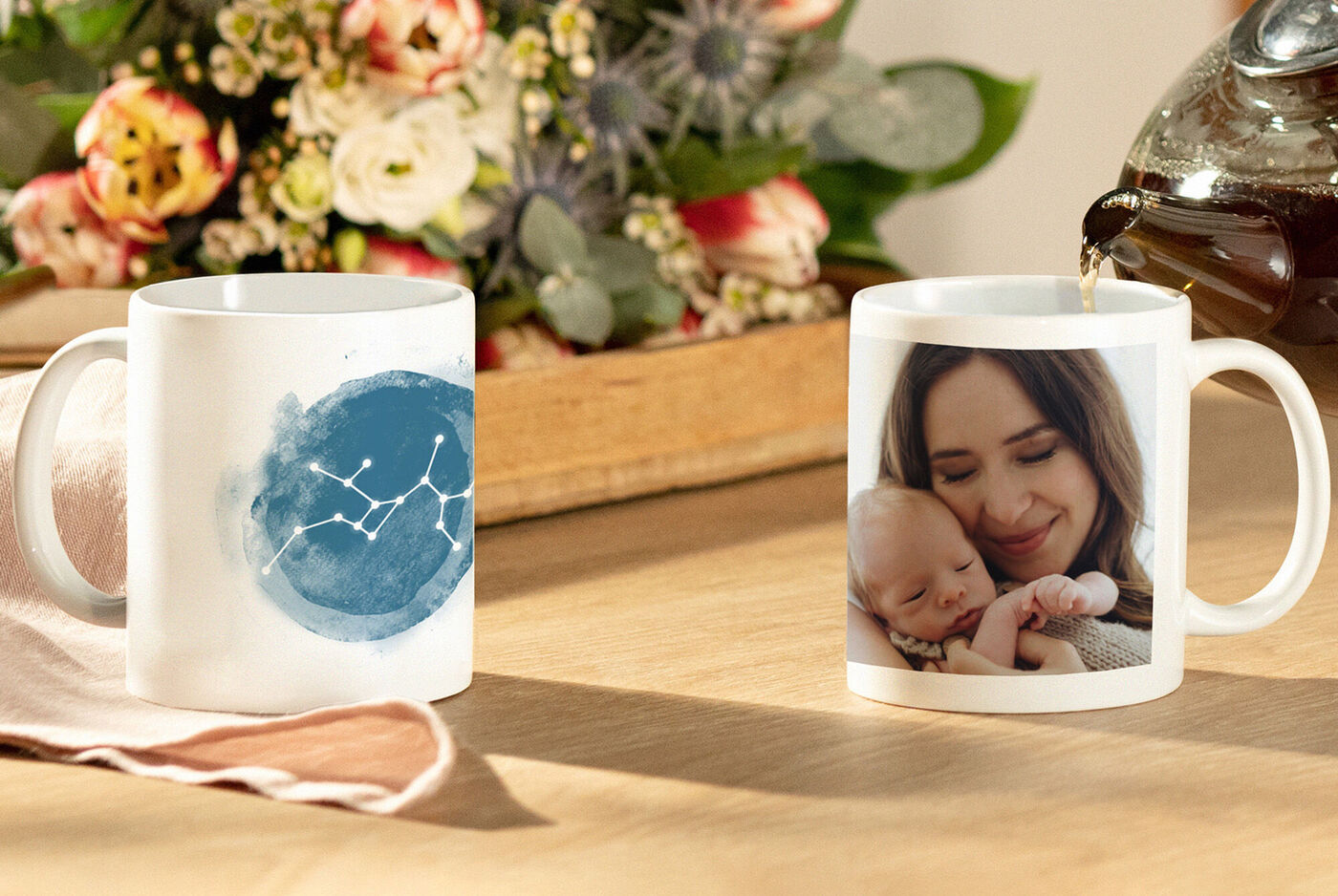 2 mugs personnalisés posés sur une table, avec signe du zodiaque et une photo d'une maman portant son bébé
