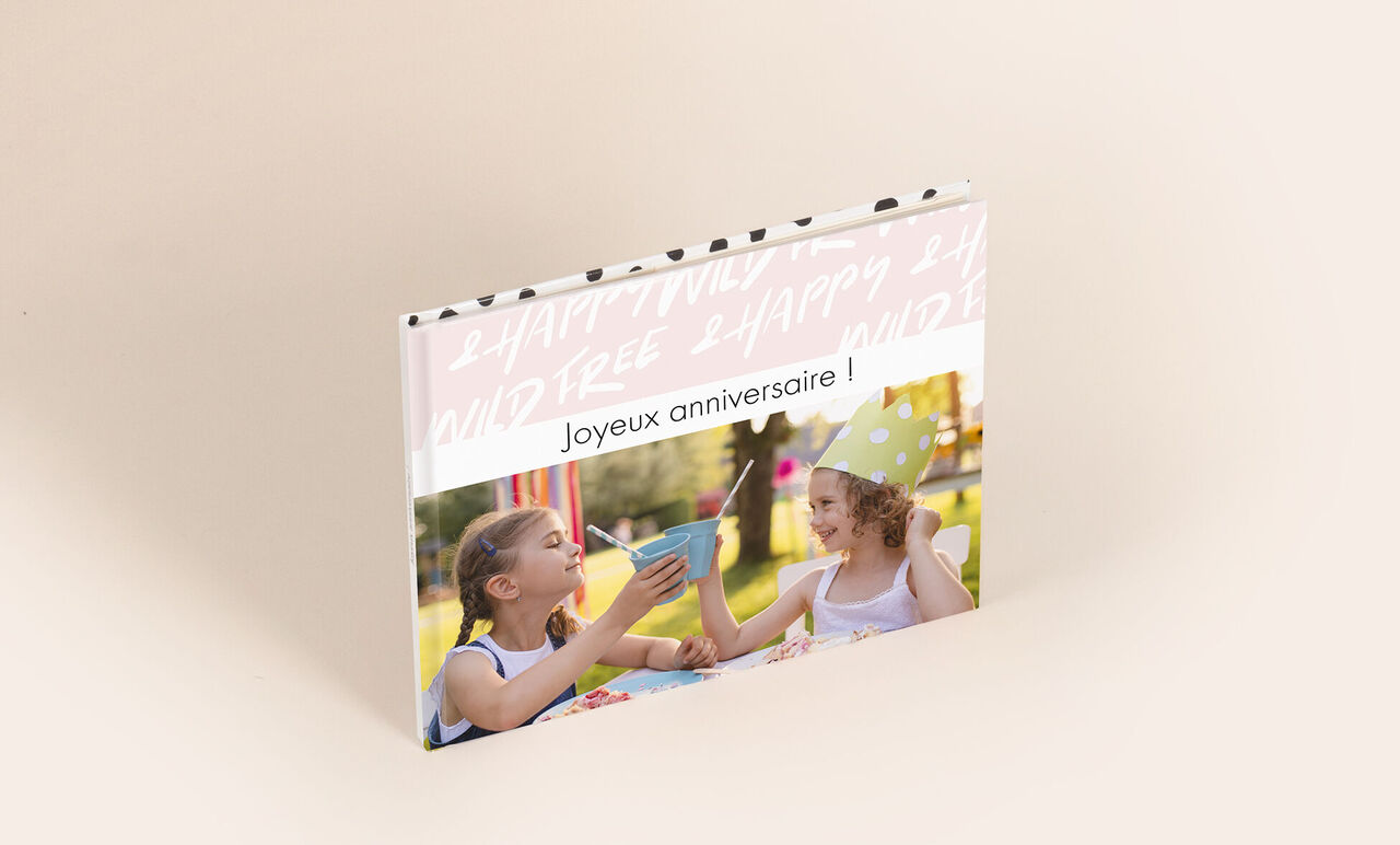 Un album photo A5 paysage 19x15 cm avec en couverture une photo d'enfants et écrit dessus Joyeux Anniversaire