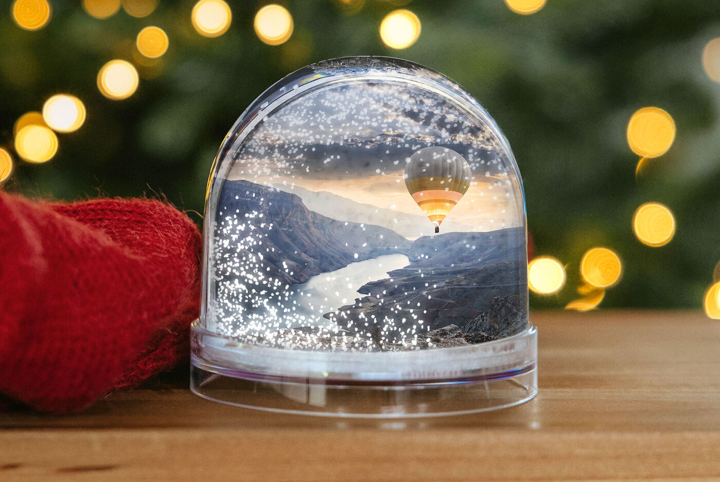 Boule à neige personnalisée avec une photo de montgolfière et un sapin en arrière plan
