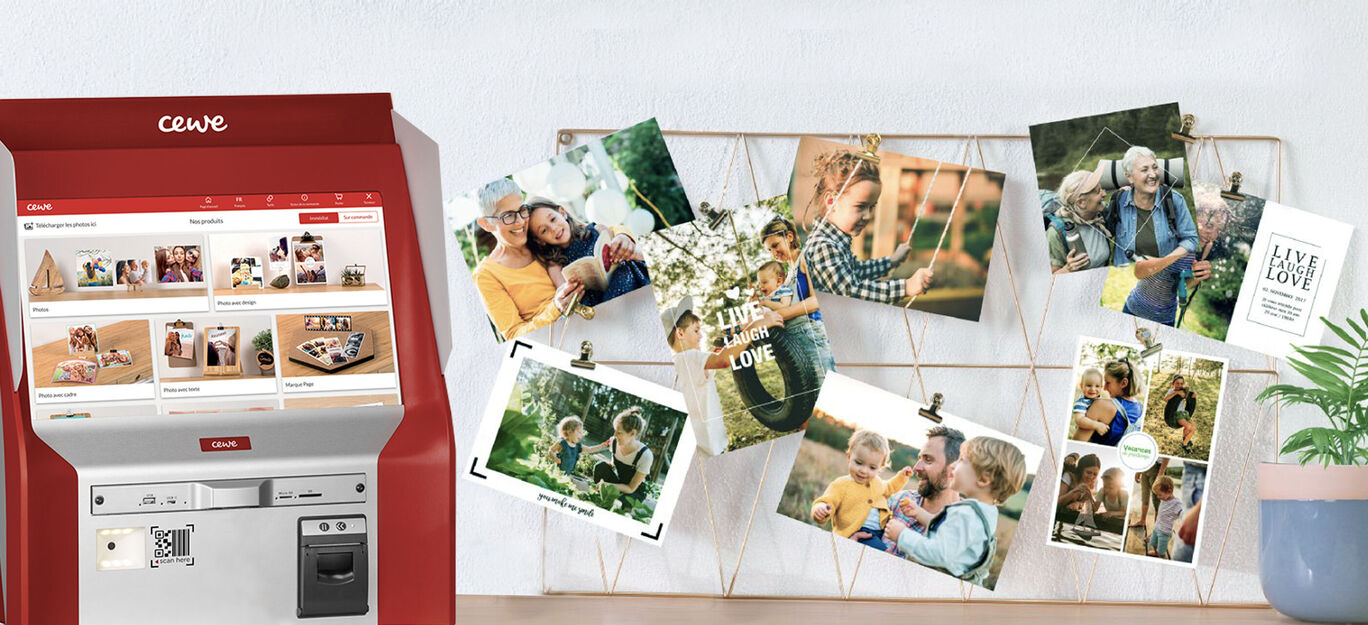 Borne d'impression photo CEWE avec des photos de famille accrochées sur une décoration murale