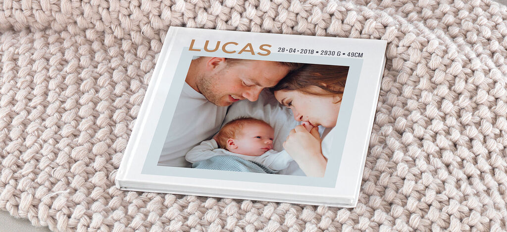 Album photo carré posé sur une couverture avec la photo d'un bébé