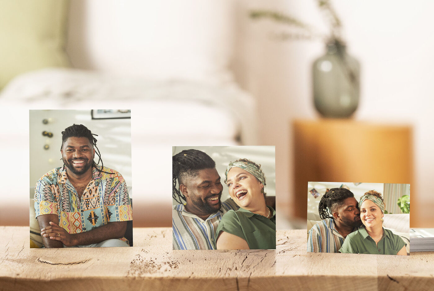 Trois photos sur une table avec une plante en arrière-plan.