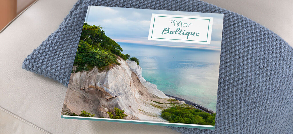 Grand album carré posé sur un canapé avec une photo de la mer Baltique