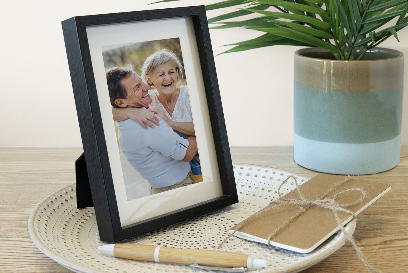 Une photo encadrée avec amour sur une table, entourée d'un carnet et d'un stylo.