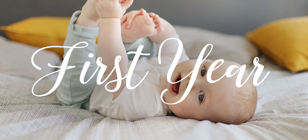Un bébé joue sur un lit, levant les jambes dans les airs, entouré d'oreillers.
